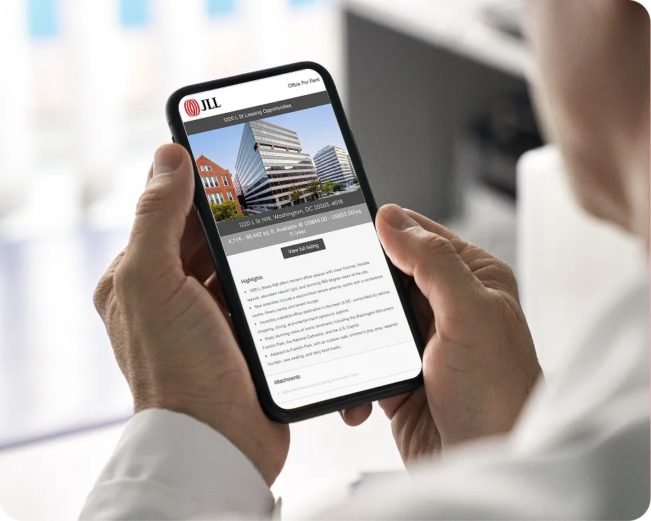 Person holding a phone displaying a JLL email campaign for a Washington, DC office listing, with a building photo and property highlights.
